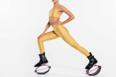 jumping boots, active lifestyle, cropped view of woman in kangoo jumping shoes on white background Poster #664865812