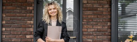 blonde woman standing with folder near new city building, successful real estate agent, banner