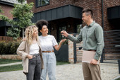 successful realtor with folder giving key from new house to pleased multiethnic lesbian couple Longsleeve T-shirt #664925448