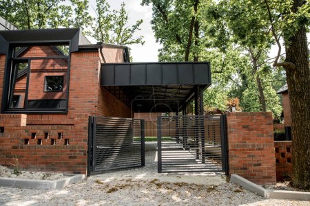 real estate market, brick modern cottage with metal fence and large windows