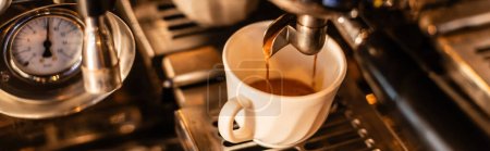 close up view of coffee pouring in white cup from coffee machine with sunlight in cafe, banner