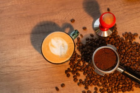vista superior de capuchino, prensa y granos de café con iluminación en la cafetería