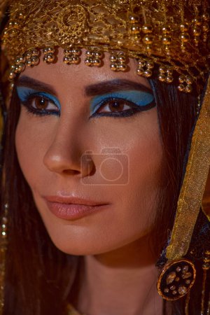 Nahaufnahme einer brünetten Frau in traditioneller ägyptischer Kopfbedeckung, die posiert und wegschaut