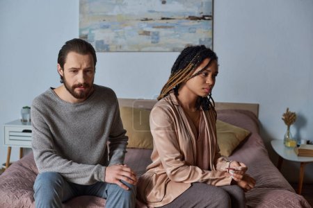 mujer afroamericana triste sosteniendo prueba de embarazo cerca de novio, pareja interracial, infeliz