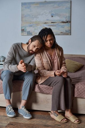 abortion concept, worried man leaning on african american woman with pregnancy test, couple mug #668922290