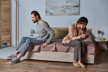 abortion concept, man and african american woman with pregnancy test, stressed couple, bedroom