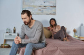 worried man sitting on bed, feeling stressed, african american woman with pregnancy test, decision mug #668922540
