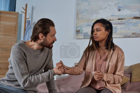 Photo for Worried african american woman with pregnancy test, couple holding hands and making decision - Royalty Free Image