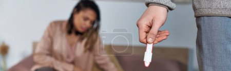 Foto de Hombre sosteniendo prueba de embarazo, mujer afroamericana molesta, posibilidad de aborto concepto, pancarta - Imagen libre de derechos