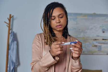 concepto de aborto, mujer afroamericana que mira la prueba de embarazo y toma de decisiones, inesperada