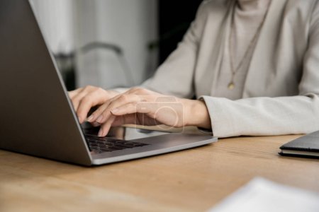 cropped of mature businesswoman, corporate manager typing on laptop at workplace