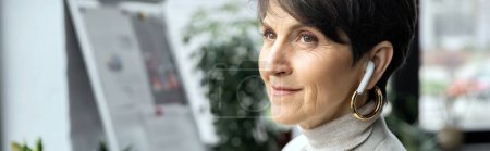 smiling and dreamy middle aged businesswoman listening music in earphone and looking away, banner