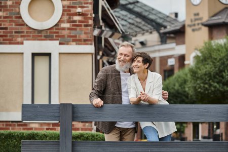 positive elderly couple, senior man and woman, husband and wife outdoors, together, urban, romance