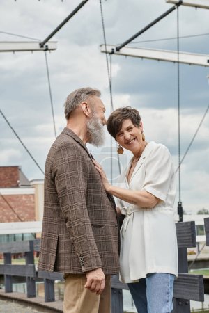 Foto de Feliz anciana mirando a la cámara, de pie cerca de hombre, marido y mujer al aire libre, romance, fecha - Imagen libre de derechos