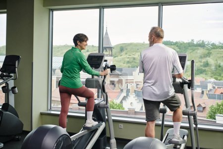 active seniors, positive woman looking at elderly man, exercising together, senior couple, sport
