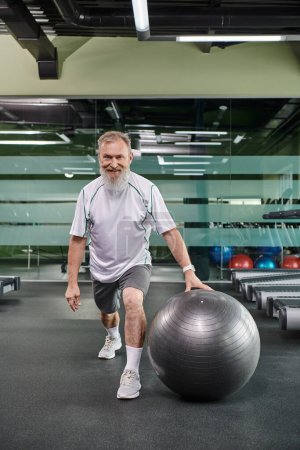 happy elderly sportsman doing lunges near fitness balls, sport and fitness, senior work out, active