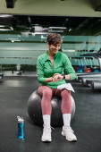 happy elderly woman sitting on fitness ball, looking at fitness watch after workout, sports bottle Stickers #669963054