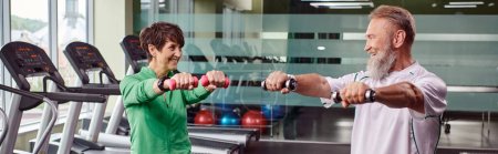 elderly couple, happy man and woman training with dumbbells, husband and wife, horizontal, banner