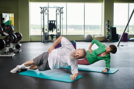 Foto de Anciano y mujer haciendo tablón lateral en colchonetas de fitness, personas mayores activas haciendo ejercicio en el gimnasio - Imagen libre de derechos