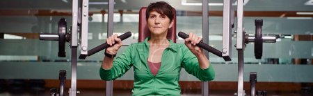 starke und motivierte ältere Frau, die im Fitnessstudio trainiert, reife Fitness, Energie, aktive Senioren, Banner