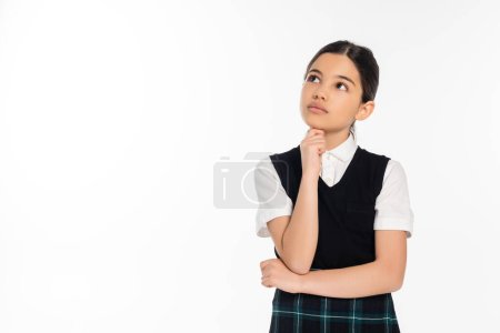 nachdenkliches Schulmädchen in schwarzer Weste, das isoliert auf weiß blickt, denkend, Schuluniform, Schulkind