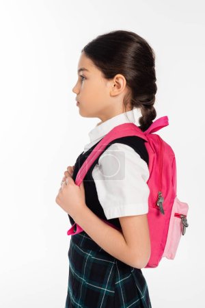 Foto de Vista lateral, preadolescente colegiala de pie con mochila rosa aislada en blanco, concepto de vuelta a la escuela - Imagen libre de derechos