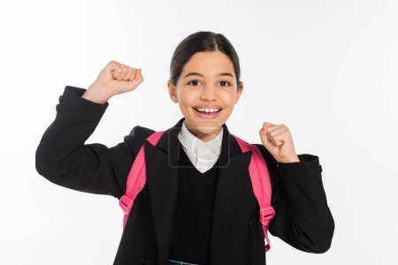 excited schoolgirl in uniform looking at camera isolated on white, student life, yay, positivity