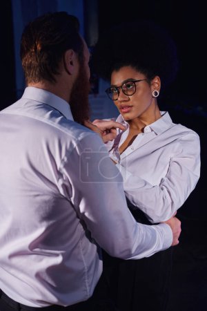 heiße afrikanisch-amerikanische Geschäftsfrau mit Brille verführt Geschäftsmann in der Nacht im Büro