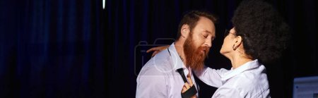 Photo for Bearded businessman with closed eyes near seductive african american woman in dark office, banner - Royalty Free Image