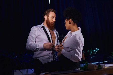 african american secretary and bearded businessman undressing and looking at each other in office