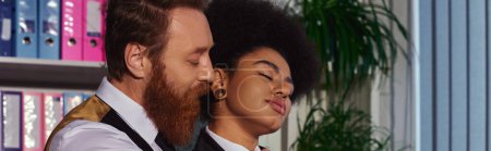 Bearded businessman near charming african american woman with closed eyes, love in office, banner