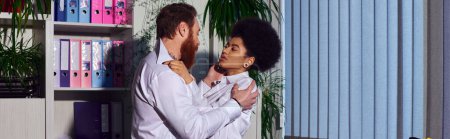 Téléchargez les photos : Vue de côté du couple multiethnique embrassant près de rack avec des dossiers la nuit, romance de bureau, bannière - en image libre de droit