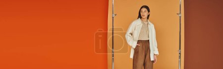 Photo for Pretty asian woman in autumn outfit posing with hand in pocket, leather pants and outerwear, banner - Royalty Free Image