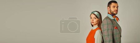 Photo for Stylish couple in old-fashioned outfit standing back to back and looking at camera on grey, banner - Royalty Free Image