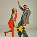 cheerful old-fashioned couple with yellow boombox dancing on grey, happiness and retro lifestyle