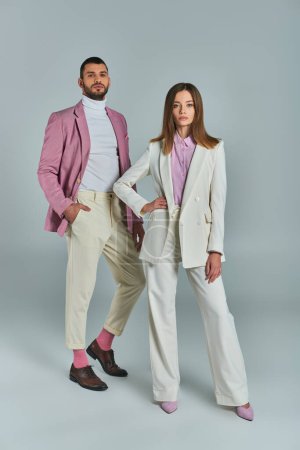 Téléchargez les photos : Longueur totale du couple d'affaires réussi dans l'usure formelle élégante posant sur gris, mode classique - en image libre de droit
