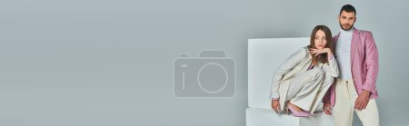Téléchargez les photos : Jeune couple en tenue formelle élégante posant près de cubes blancs sur gris, mode minimaliste, bannière - en image libre de droit