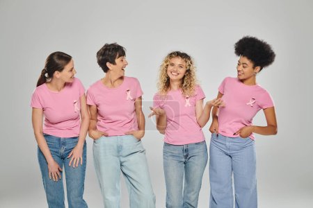 breast cancer awareness, happy interracial women with pink ribbons on grey, diversity, conceptual