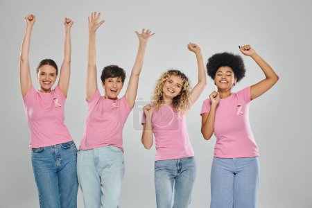 Téléchargez les photos : Sensibilisation au cancer du sein, étonnantes femmes interracial avec des rubans roses sur le gris, la diversité, sans cancer - en image libre de droit