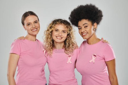 breast cancer awareness, interracial women with pink ribbons on grey, diversity, smile, cancer free
