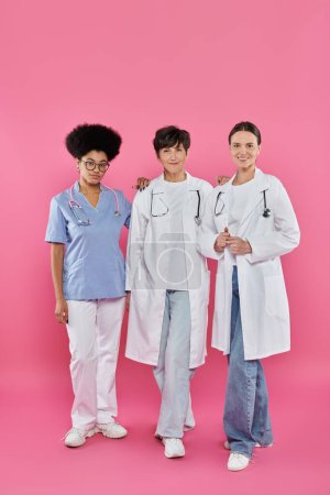 Photo for Oncologists, three interracial female doctors, breast cancer awareness, early detection, campaign - Royalty Free Image