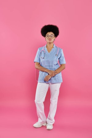 conciencia del cáncer de mama, médico afroamericano, oncólogo femenino con estetoscopio, telón de fondo rosa