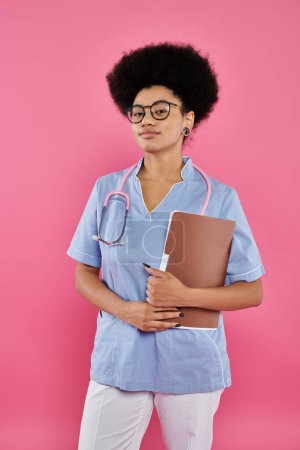 conciencia del cáncer de mama, médico afroamericano, oncólogo femenino con carpeta, fondo rosa