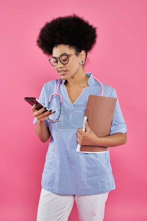 concienciación sobre el cáncer de mama, médico afroamericano, oncólogo feliz con carpeta usando smartphone