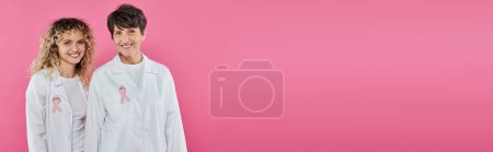 médecins souriants avec rubans sur manteaux blancs isolés sur rose, bannière, concept de cancer du sein