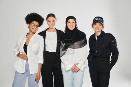 fröhliche Gruppe multiethnischer Frauen posiert isoliert auf grau