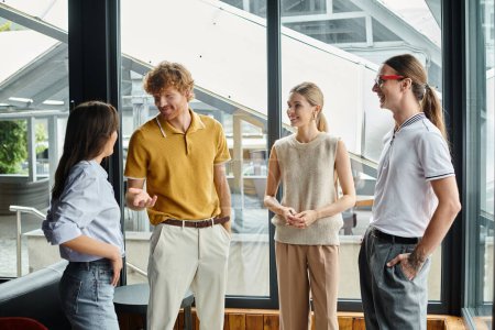 four coworkers in business casual clothing happily chatting to each other, coworking concept