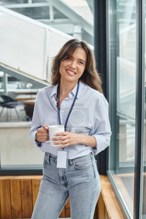 cheerful pretty woman in business casual outfit smiling and looking at camera, coworking concept