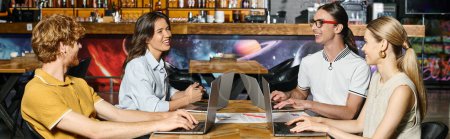 young team working using their laptops with blurred bar on background, coworking concept, banner-stock-photo