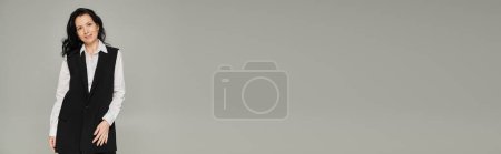Téléchargez les photos : Brunette femme d'affaires d'âge moyen en tenue formelle regardant la caméra sur gris, bannière, espace de copie - en image libre de droit